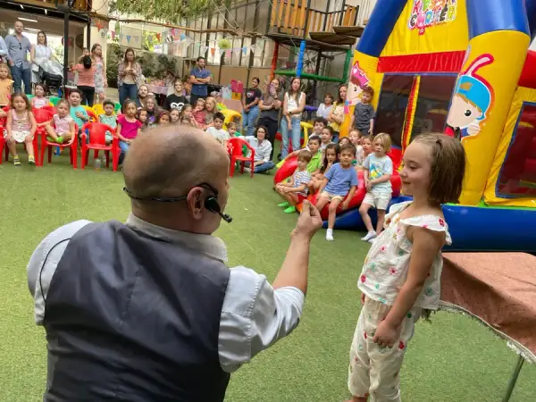 Mago Konstant ante una multitud de niños en una fiesta