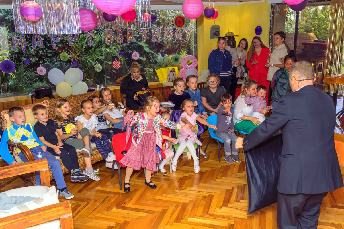 Niños emocionados en una fiesta infantil de cumpleaños con magia